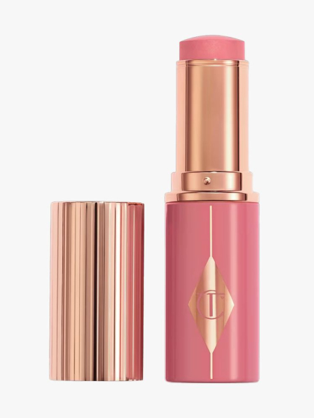 Charlotte Tilbury Unreal Lip + Cheek Glow Blush Stick with Hyaluronic Acid in branded component on a light gray background
